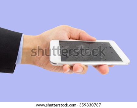 businessman holding modern smart phone with water drops on blue background