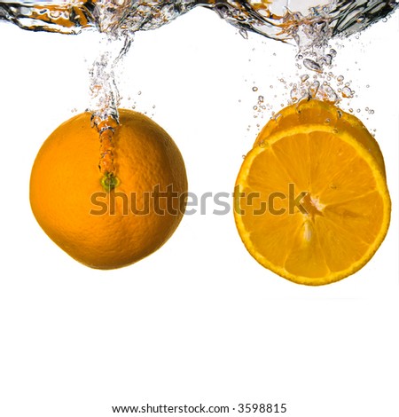 A whole orange and slices dropped onto water.