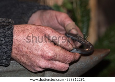 old retired man hand detail while working iron 