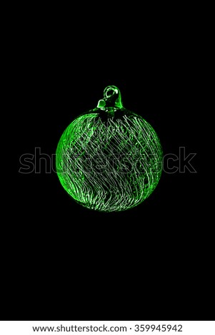 green transparent glass christmas ball with frizz ornamnent on black background