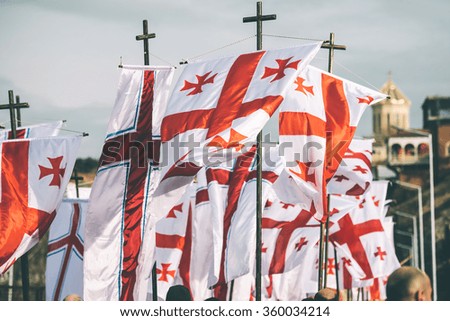 The national flags of Georgia during one of the religious holidays. Toned picture. Selective focus