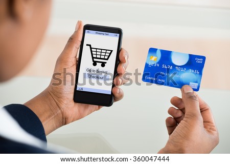 Close-up Of A Woman Using Card While Shopping On Mobile Phone