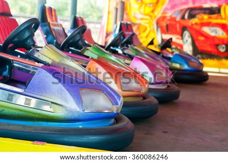 Colorful electric bumper car in autodrom in the fairground attractions at amusement park. Selective focus on the cars Royalty-Free Stock Photo #360086246