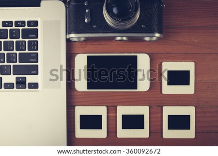 retro camera and some old photos on wooden table. Vintage look