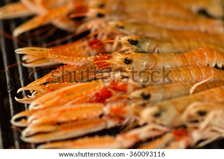 Photo closeup of delicious hot orange prawns shrimps shellfish grilled seafish cooked on grill charbroiled barbecue on brazier on blurred background, horizontal picture
