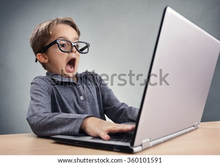 Shocked and surprised boy on the internet with laptop computer concept for amazement, astonishment, making a mistake, stunned and speechless or seeing something he shouldnt see Royalty-Free Stock Photo #360101591