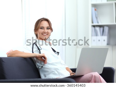 Closeup portrait of a young doctor sitting on the sofa