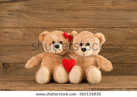 two teddy Bear with Heart on wood background