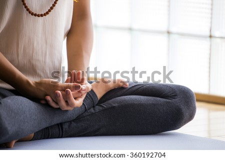 Young latin woman practicing meditation indoors. Royalty-Free Stock Photo #360192704