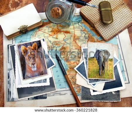 Image from a pile of old images on a desk and vitage objects with blurred background. The images on top are taken during a safari at the serengeti N.P. showing a lion and elephant