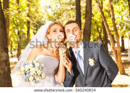 Wedding couple posing with stick lips, mask Royalty-Free Stock Photo #360240854