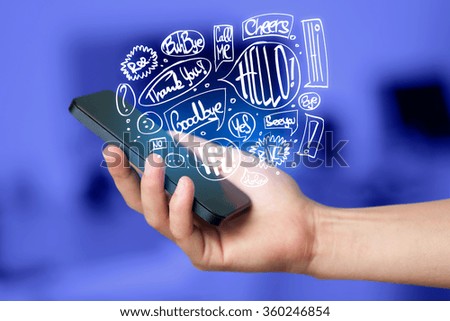 Hand holding phone with hand drawn speech bubbles concept