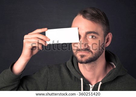 Handsome man holding copy space paper at his eye concept