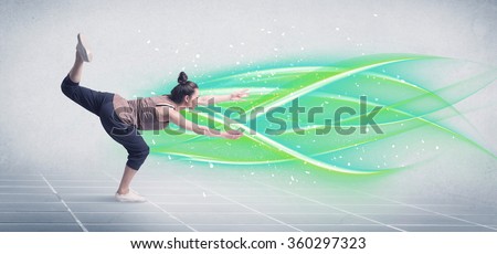 A good looking fresh street dancer dancing in front of grey background with white and bright, colorful green lines concept