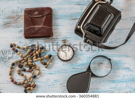 Travel concept with old camera,wallet pocket watch and magnifying glass on wooden background