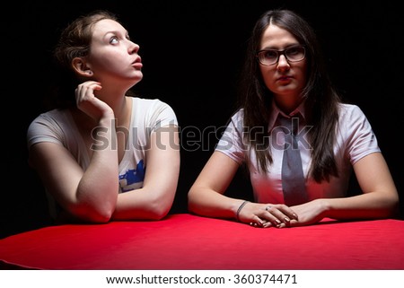 Two woman on a boring interview, black background