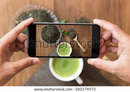 closeup hand holding phone shooting drink photograph Royalty-Free Stock Photo #360374972