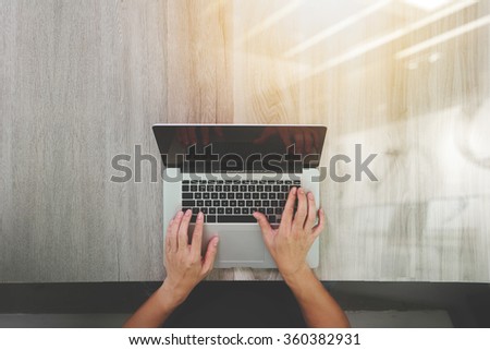 top view of Designer hand working with laptop computer on wooden desk as responsive web design concept