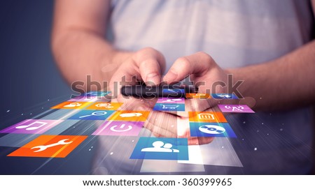 Man holding smart phone with colorful application icons comming out Royalty-Free Stock Photo #360399965