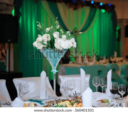 Bunch of white roses at a festive wedding table.