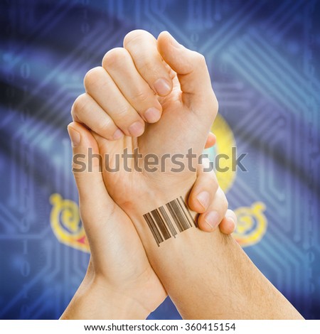 Barcode ID number tattoo on wrist and USA states flag on background series - Idaho