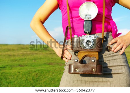 Young woman with old camera outdoor.