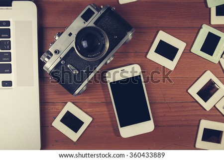 retro camera and some old photos on wooden table. Vintage look