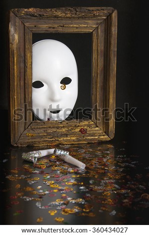 White mask in an old frame on a black background