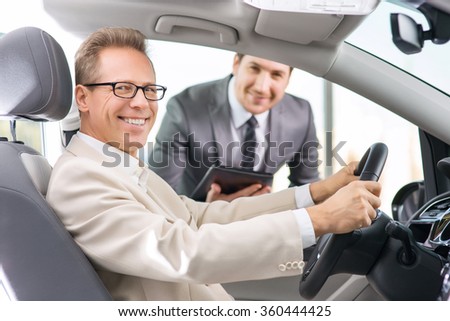 Sale assistant showing car to customer 