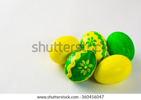 Yellow and green hand-painted Easter eggs with floral design on a white background. Easter background. Easter eggs. Copy space