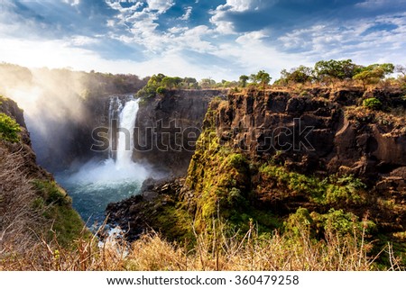 The Victoria falls is the largest curtain of water in the world (1708 meters wide). The falls and the surrounding area is the National Parks and World Heritage Site - Zambia, Zimbabwe  Royalty-Free Stock Photo #360479258