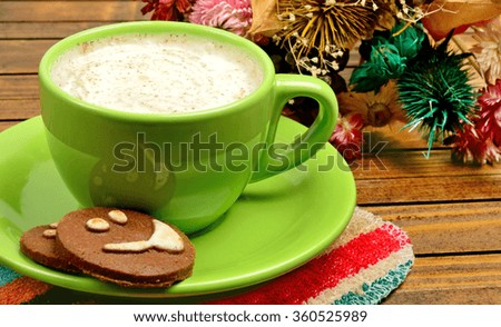 Cup of cappuccino with cocoa biscuits on wooden table
