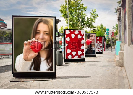 Love billboards, photographs of a woman with red heart, at city street in valentineÂ´s day