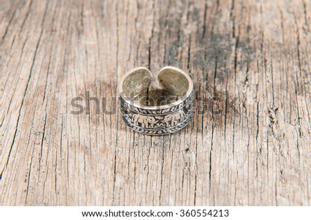 Silver ring on wooden texture