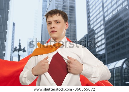 Businessman showing the superhero suit under his shirt with cityscape in the background