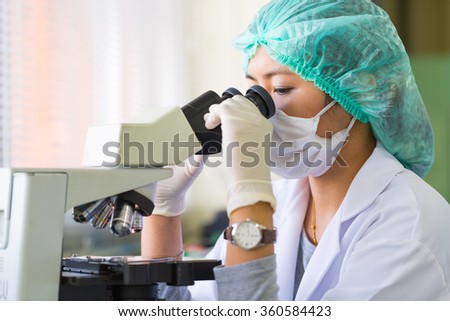 Scientist using a microscope in a laboratory