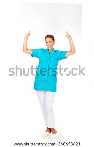 Young female doctor or nurse holding empty banner