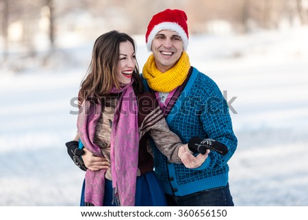 Happy couple having fun ice skating on rink outdoors. Winter sport and leisure concept. Love and fun in wintertime.