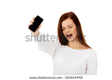 Young screaming woman shows broken touch screen mobile phone