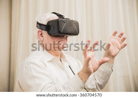 Close-up old man  getting experience using VR-headset glasses of virtual reality  at home