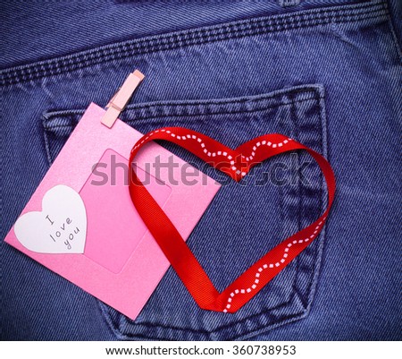 Textile hearts and pink photo frame. Romantic love theme on jeans background. Toned.