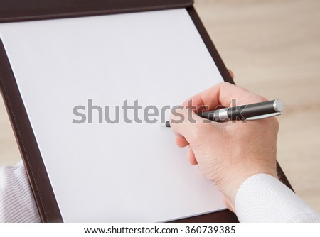 Unrecognizable businessman signing a contract in informal atmosphere