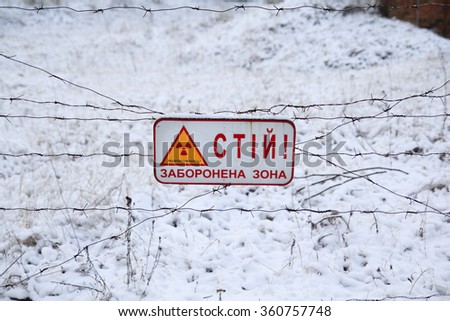 sign "STOP! RESTRICTED AREA. RADIOACTIVITY' on a barbwire fence in Chernobyl, Ukraine.