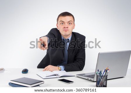 Office, business, technology, finances and internet concept - Angry businessman pointing front on gray background