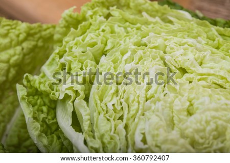 Closeup photo of half sliced fresh ripe raw green white chinese cabbage with beautiful wavy leaves, horizontal picture