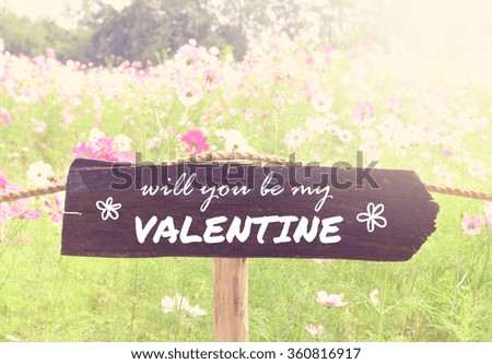 Wooden sign on blurred flowers background with vintage filter