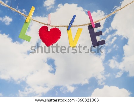 Colorful words "Love" made from wooden letters hang with rope on blue sky background  (Valentines day)