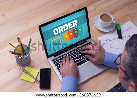 Man working on laptop with ORDER on a screen