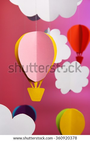 Paper clouds and airship on purple background