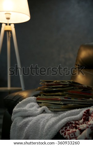 Pile of books on leather chair in the room, close up